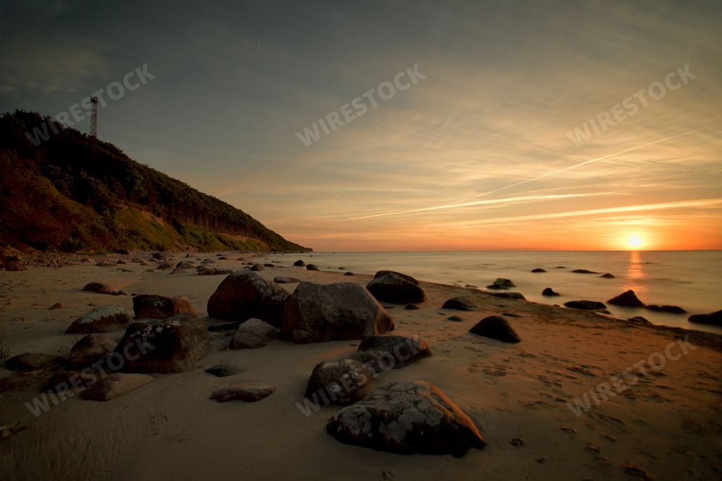 A scenic sunset at the Baltic sea under wispy clouds