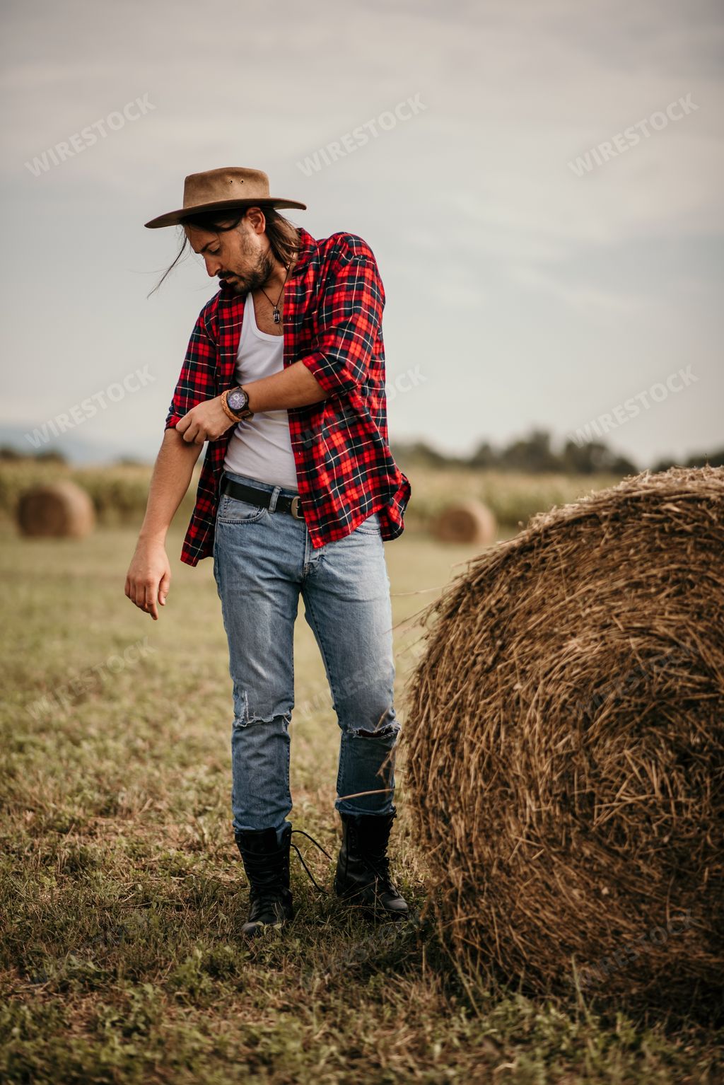 A young handsome Serbian male straightening his flannel shirt