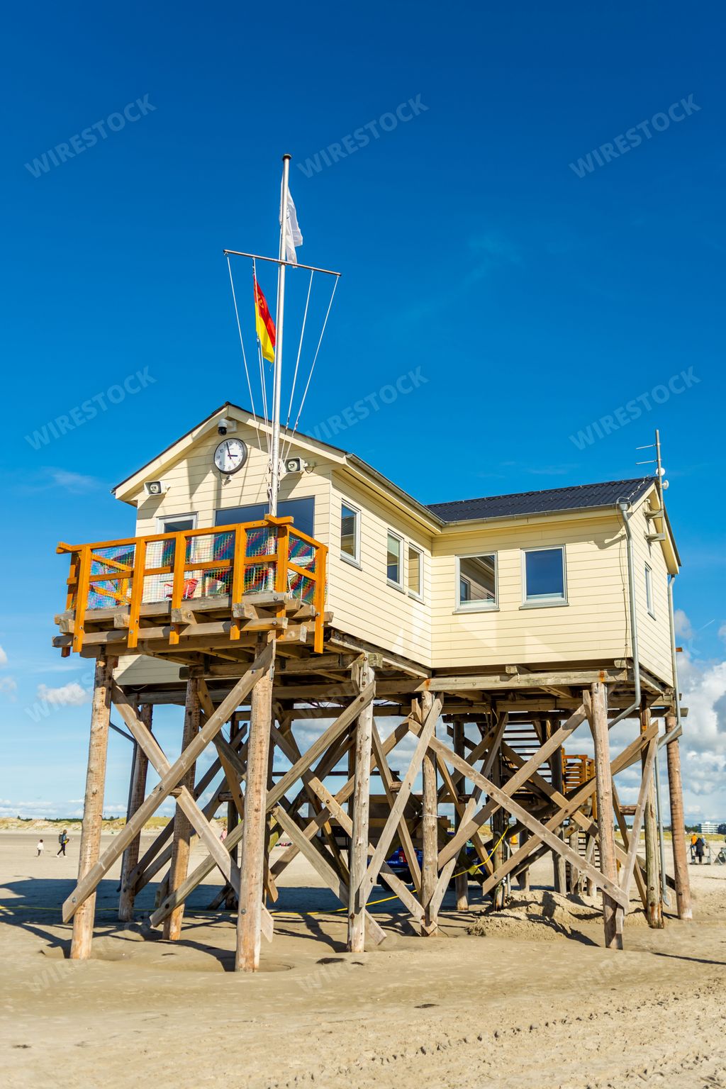 A vertical shot of a lifeguard cabin on the sandy beach in St. Peter-Ording against the blue sky