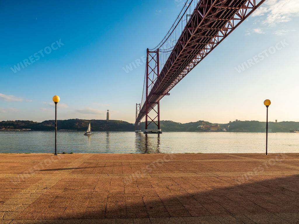 A view of 25 de Abril suspension bridge across the river in Lisbon, Portugal on a sunny day