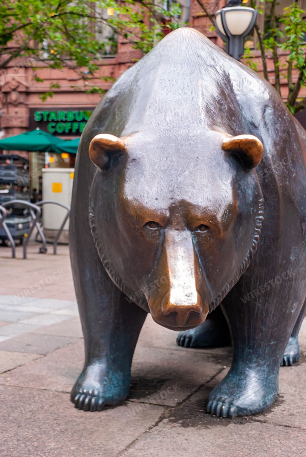 A vertical shot of a metal bear statue in the park in front of Frankfurt stock exchange