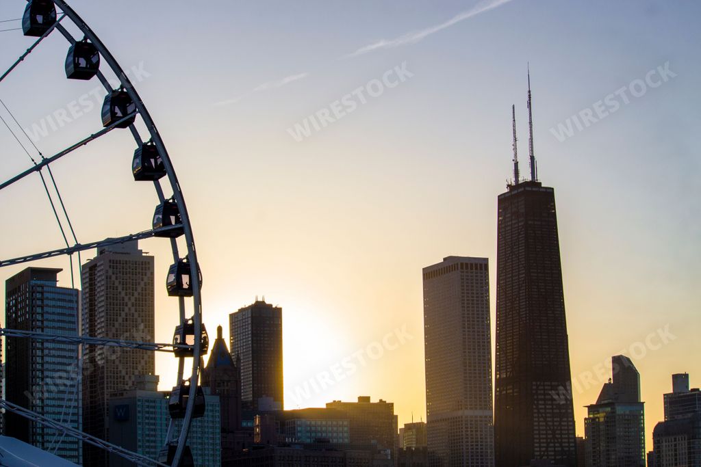 A Ferris wheel with city skyline against sunset at Navy Pier,Chicago