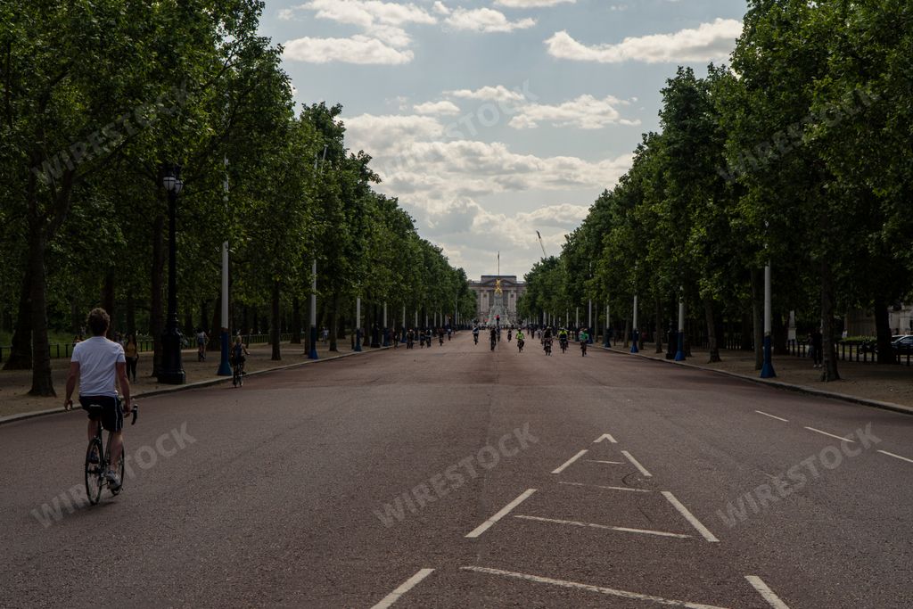 The road to Buckingham Palace with people walking and biking on a sunny day
