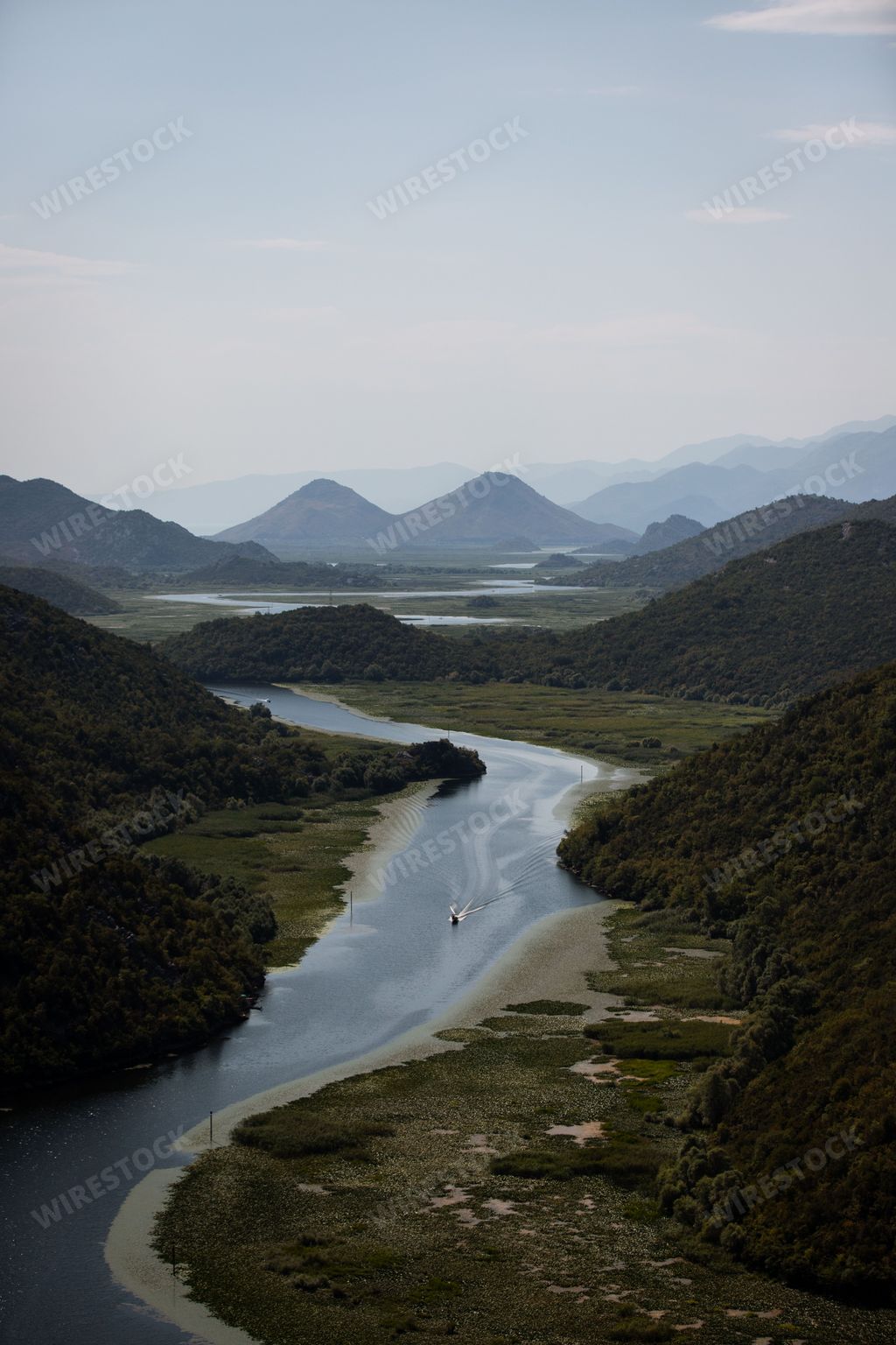 An aerial view of Rijeka Crnojevica river surrounded by lush green vegetation of Montenegro