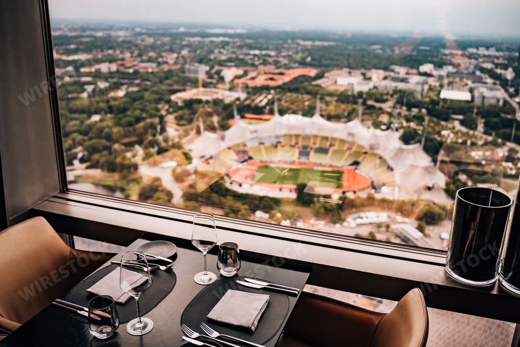 A cafe table in front of a window with a scenic view of a stadium in the background