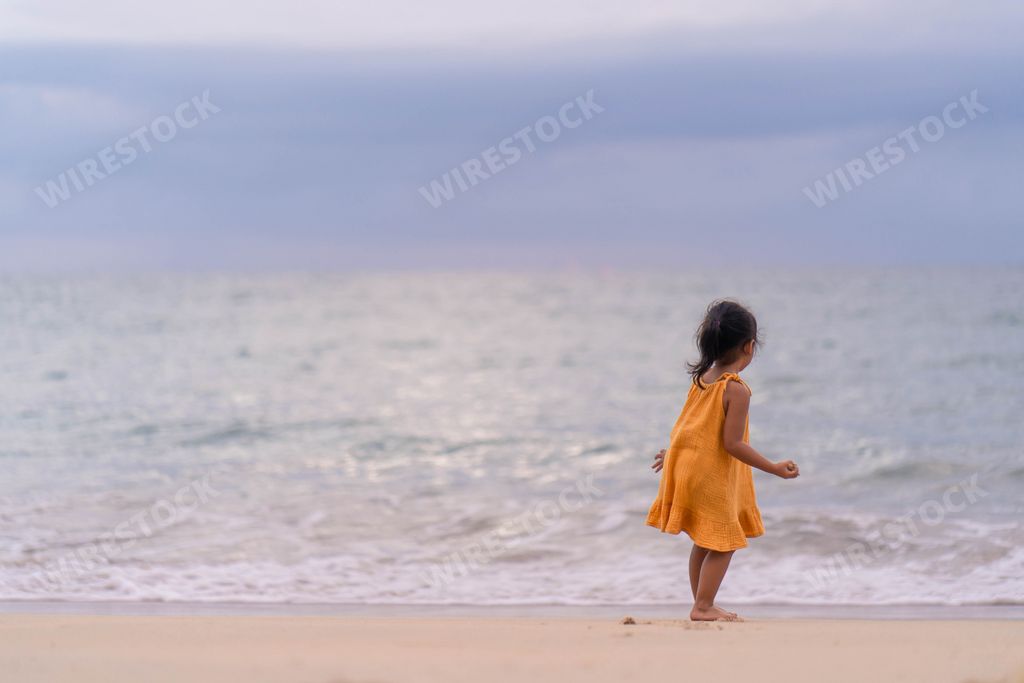 A back view of a cute little Thai girl at the beach