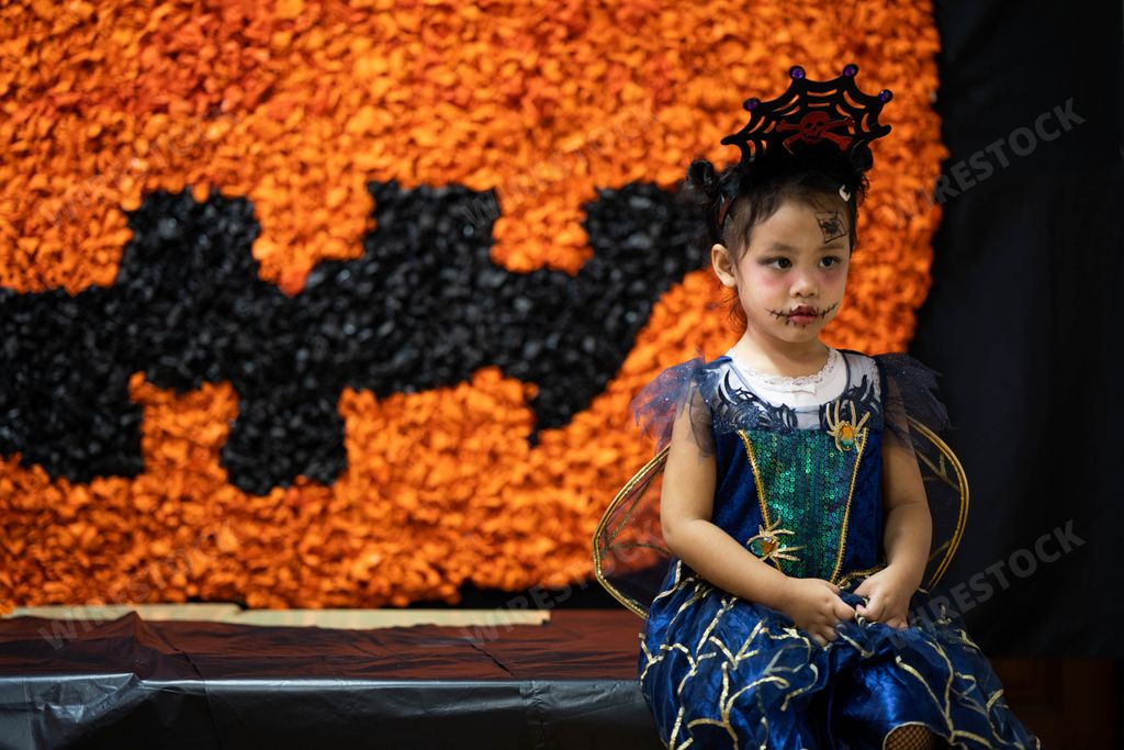 A close up of a Southeast Asian sitting wearing traditional dress and makeup at a festival in Thailand