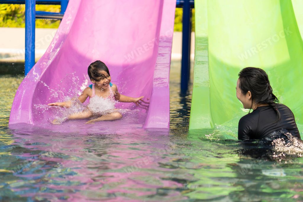 A scenic view of a Southeast Asian mother and daughter swimming in the pool