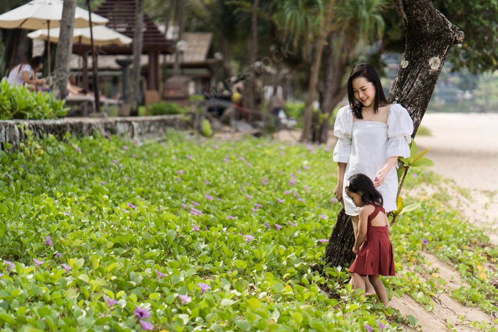 A Southeast Asian mother and her daughter having a great time on the beach in Thailand