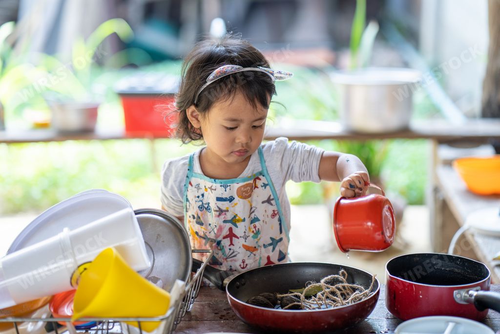 A little Thai girl cooking in the kitchen