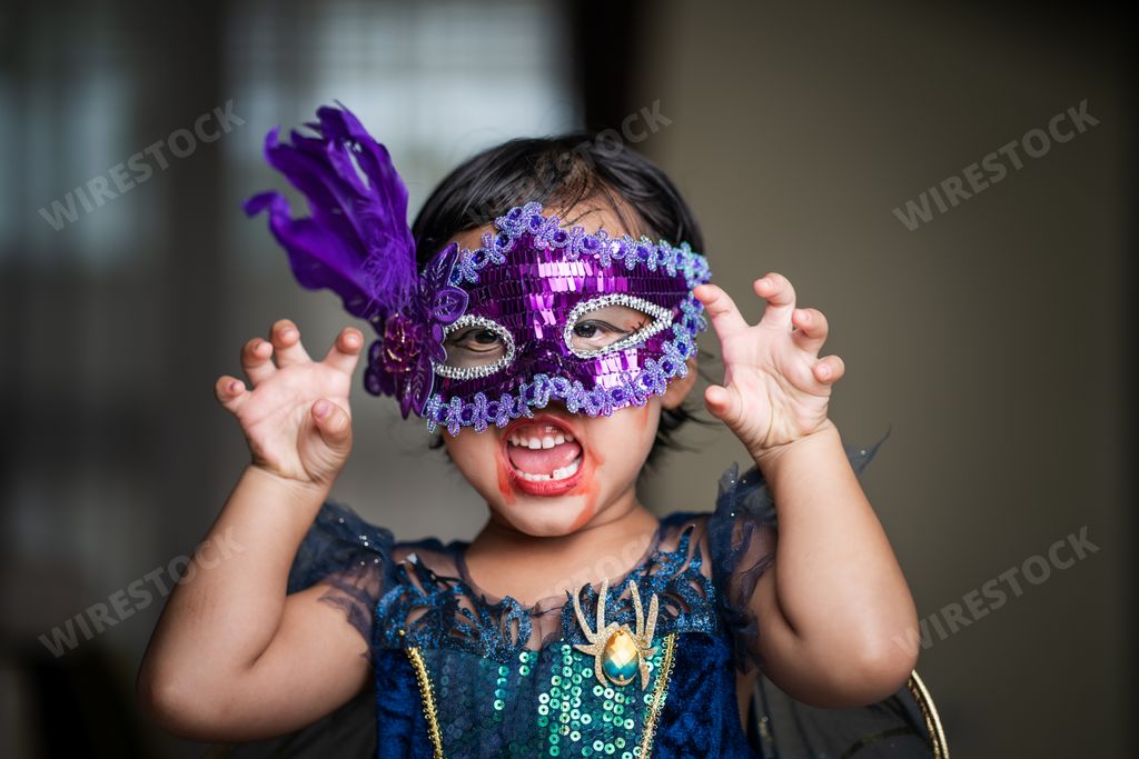 A shallow focus shot of a cute Southeast Asian girl from Thailand in a Halloween costume and makeup