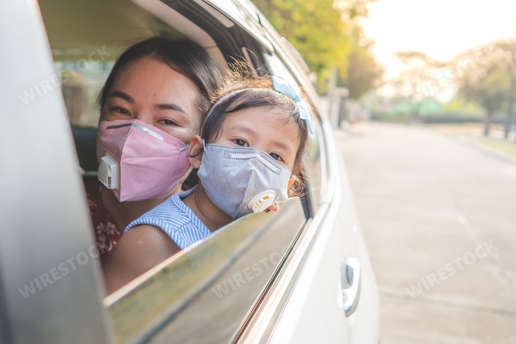 A Thai mother and daughter wearing a face mask to prevent viruses looking through car window