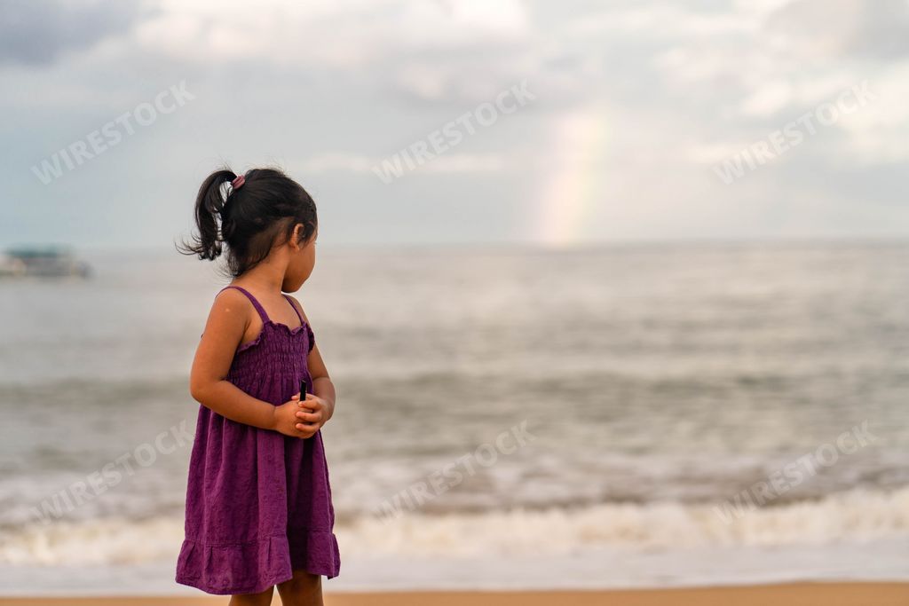 A cute little girl from Thailand enjoying the sunny day on the beach