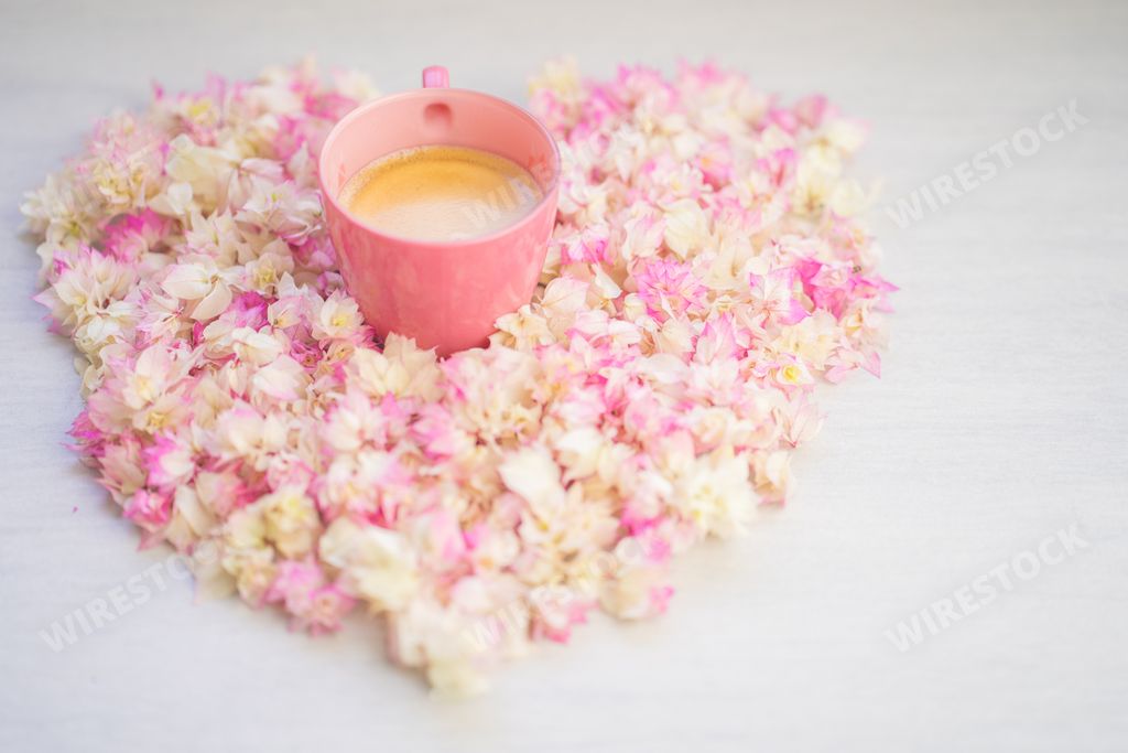 A heart made of Bougainvillea flowers with a coffee mug in the center
