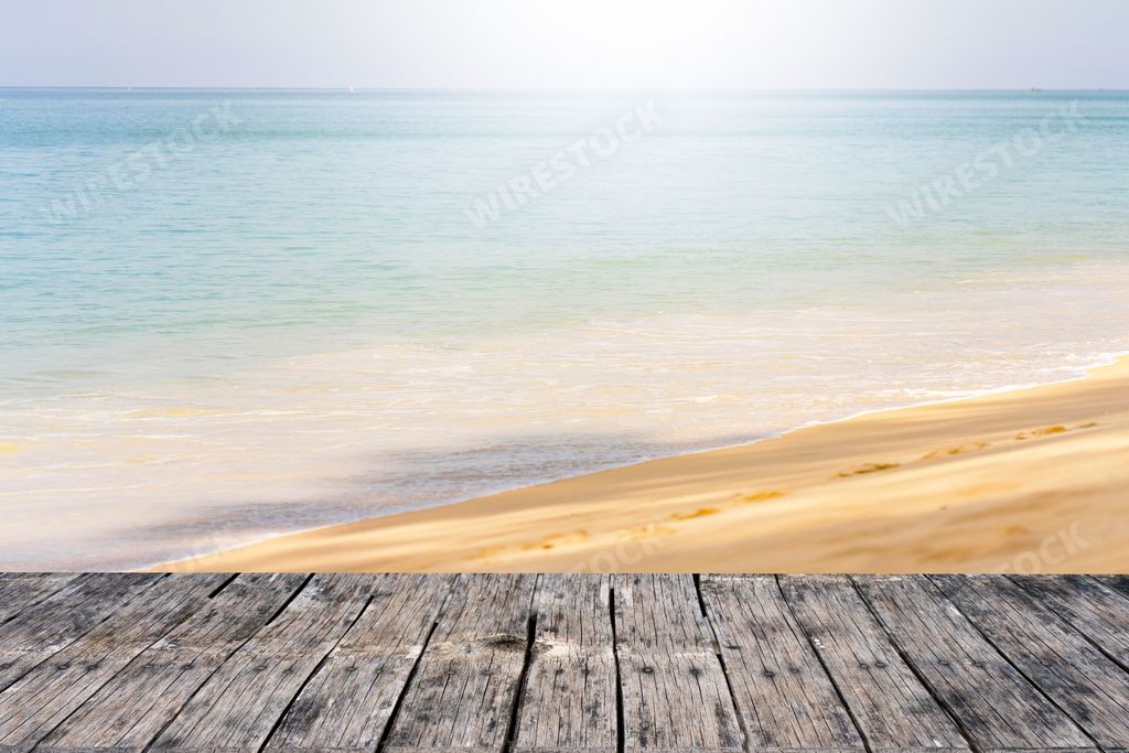 A 3D rendering of a sandy beach against a blue sea on a sunny day seen from a porch