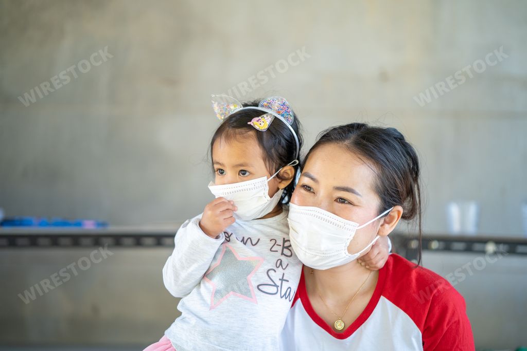 A Southeast Asian mother and daughter wearing a facial mask for preventing the virus