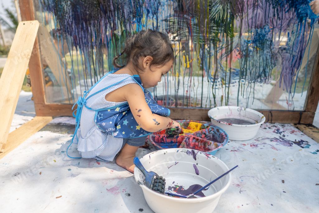 A cute little Thai girl painting on a glass
