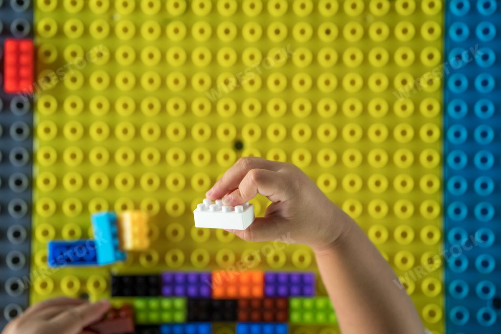 A top view of a child playing with colorful building blocks