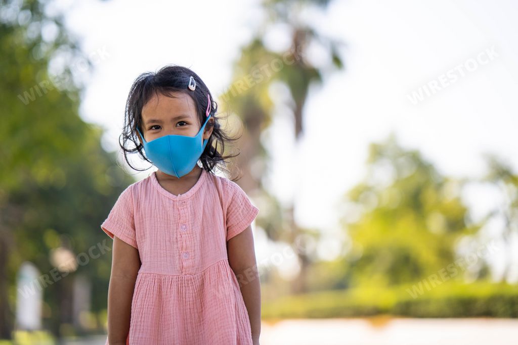 A cute girl with a protective face mask walking outdoor