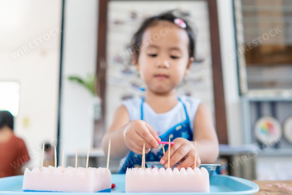 A closeup shot of an Asian female child playing with a toy