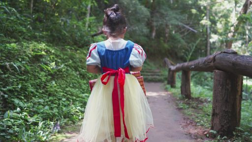 Back view of an adorable small Thai girl in a cute dress walking in the park in 4K Stock video | Wirestock