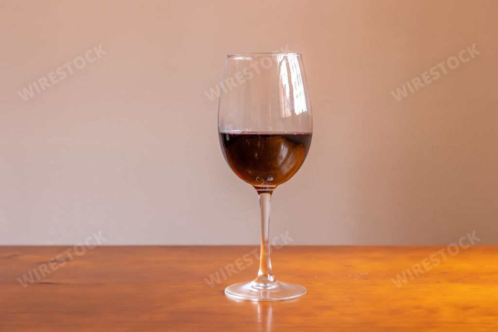 a closeup of a red wine glass on a table