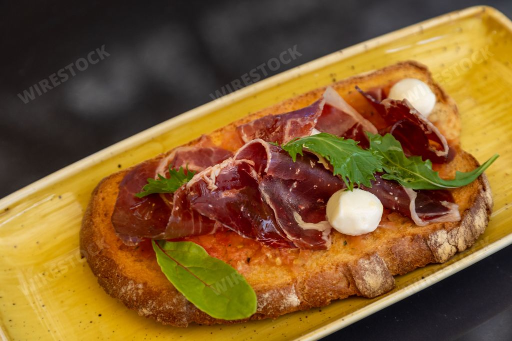 A closeup of a bruschetta with roast beef in a special plate