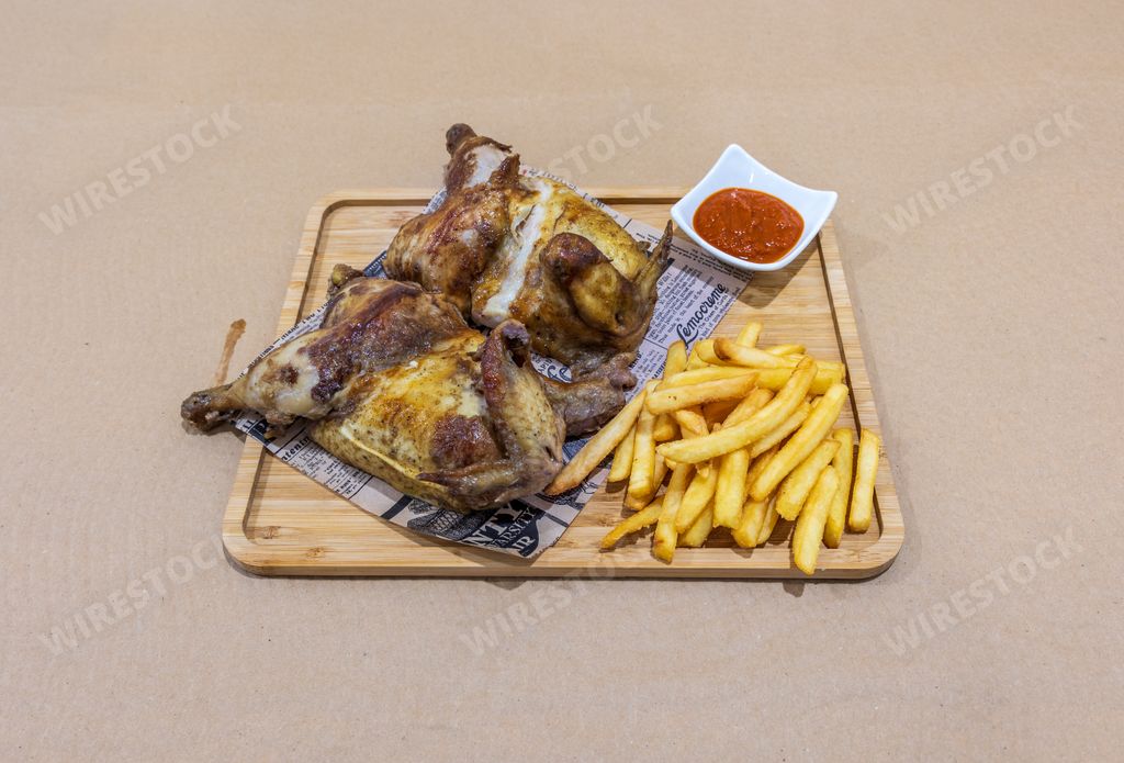 A closeup of grilled chicken with french fries and ketchup