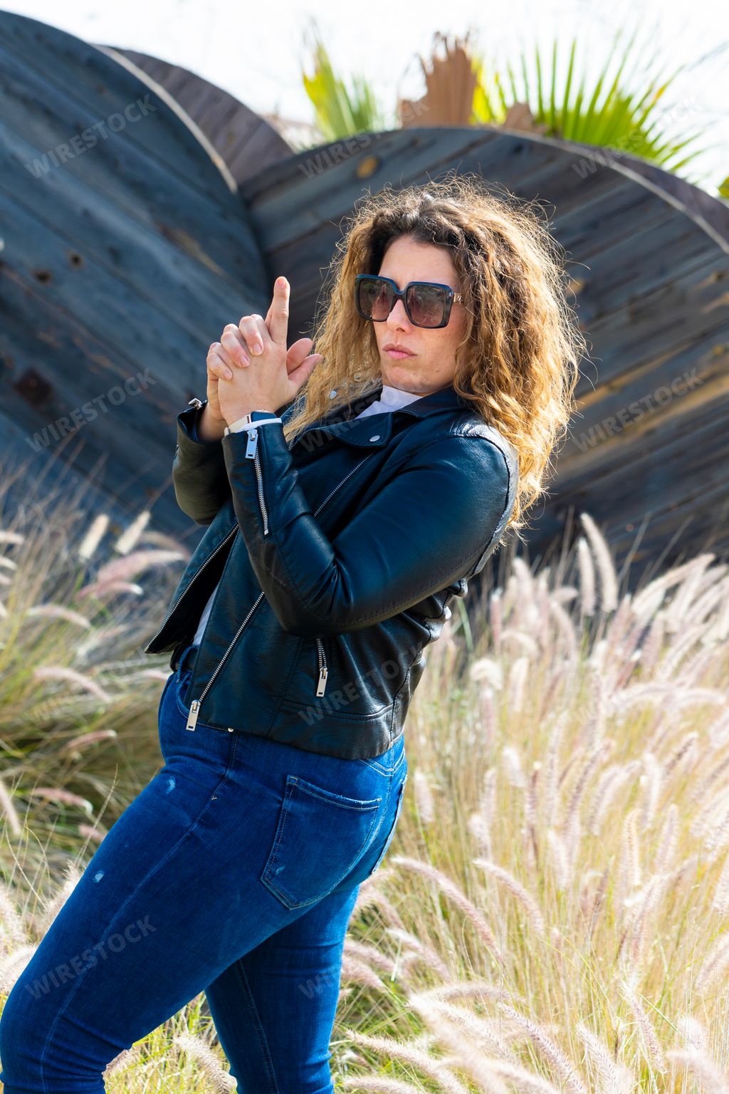 A Caucasian woman with sunglasses and blonde hair posing in the abandoned area on a sunny summer day