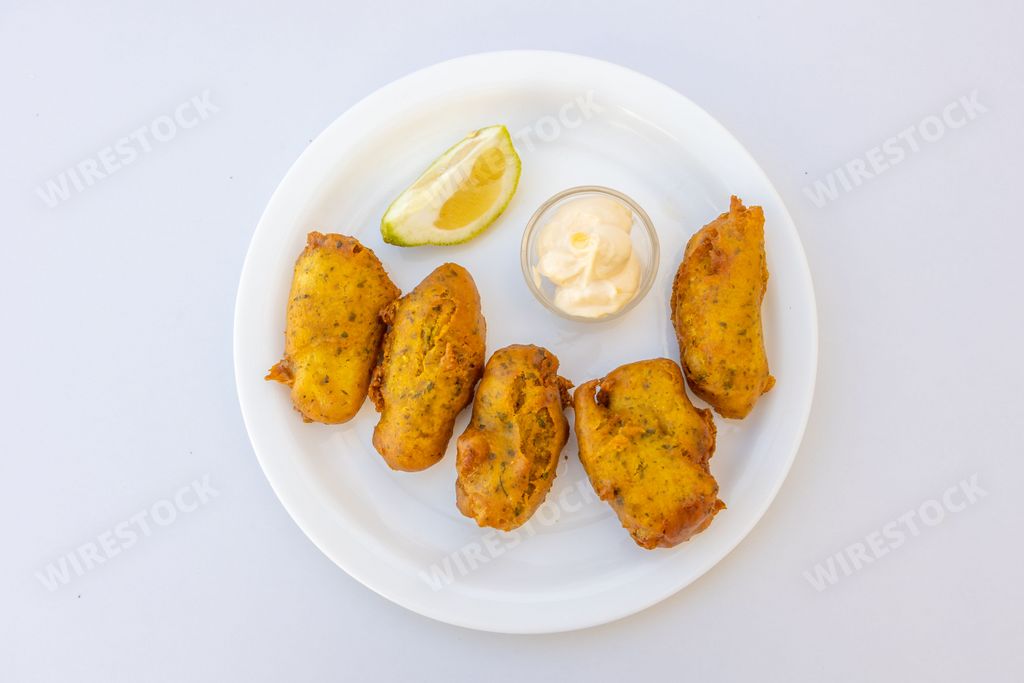 A close-up shot of chicken nuggets with a sauce on a plate