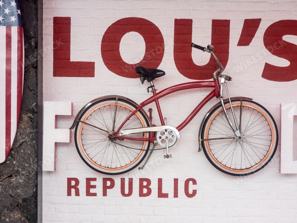 The exterior of a fast-food restaurant with a red bicycle on its facade in Santa Cruz de Tenerife, Spain