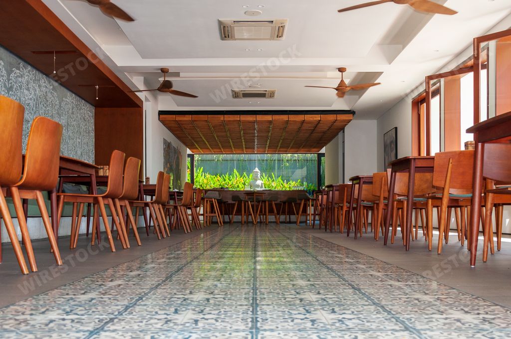 A low angle shot of a cafe with wooden chairs and tables in Phnom Penh in Cambodia