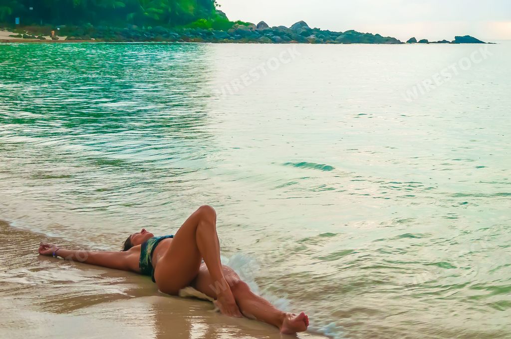 A low angle shot of an attractive Russian female laying down relaxing Freedom beach, Patong, Phuket, Thailand