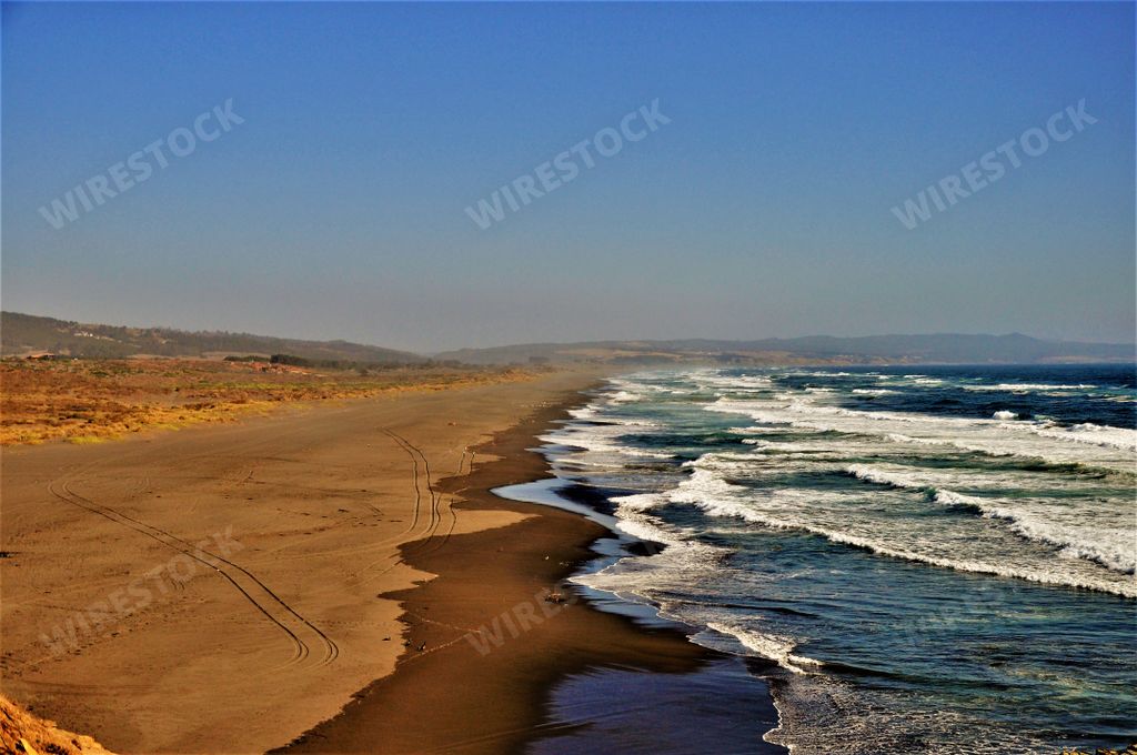 The beach near the pacific ocean in Pichilemu, Punta de Lobos, Chile under the blue sky