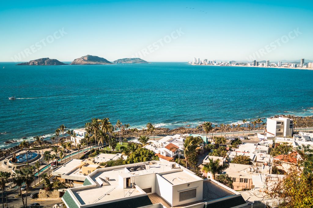 An aerial shot of a sea and buildings in Mazatlan with modern coastal buildings, Mexico