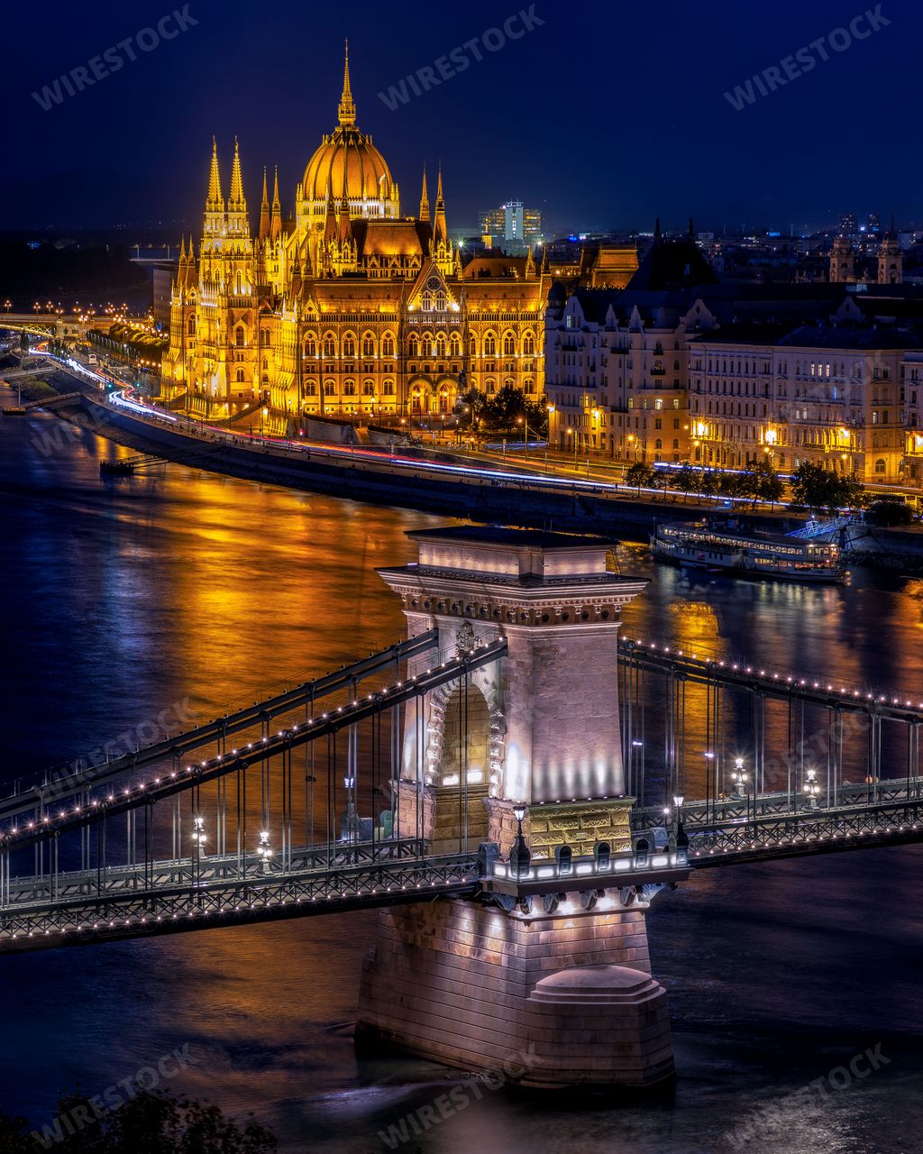 An illuminated aerial view of Budapest, Hungary, at night with the Chain Bridge over the Danube River