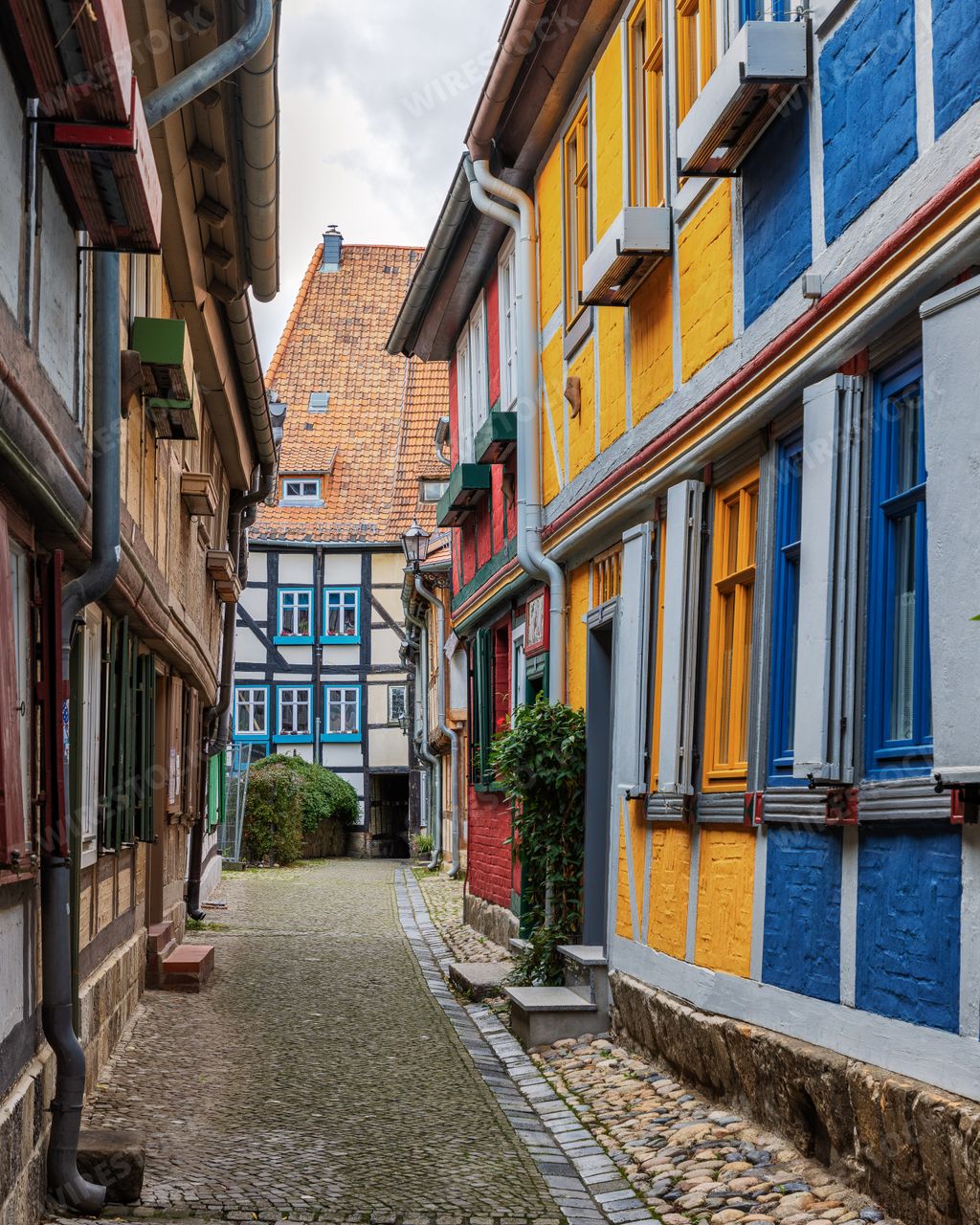 A narrow cobblestone street in Quedlinburg lined with historical buildings