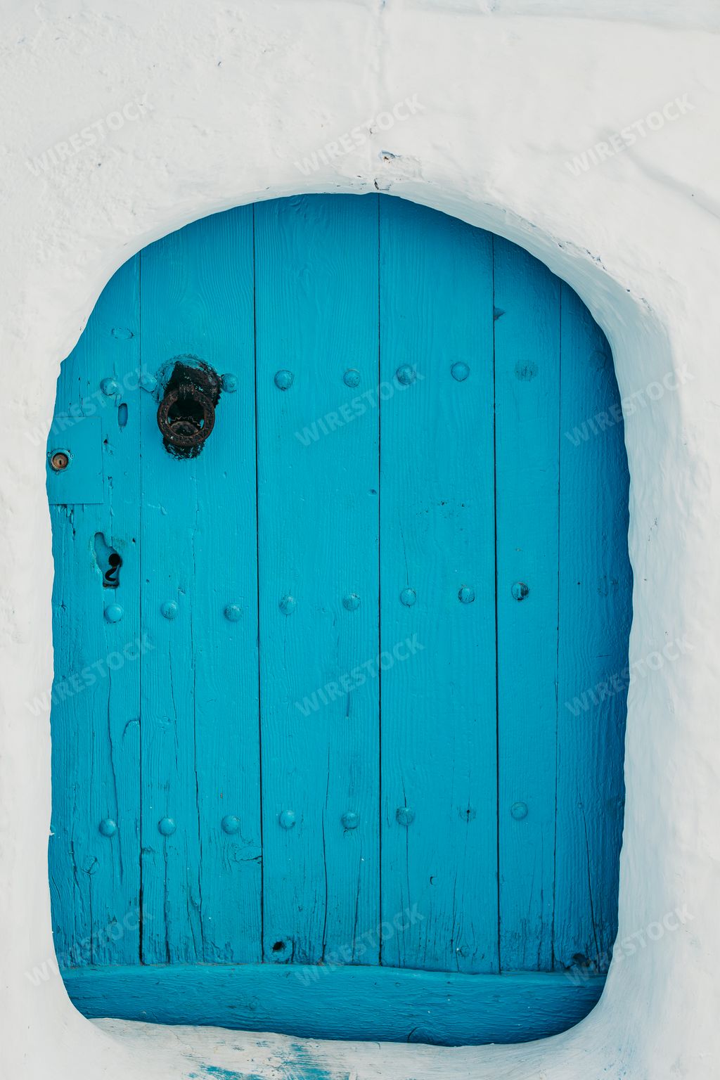 A vertical shot of an old wooden blue door of an aged building in Chefchaouen, Morocco