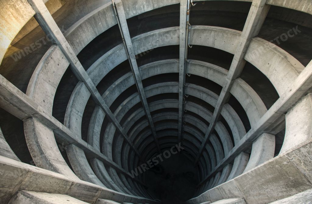 An aerial view of a spiral tunnel extending into an illusion of a deep and dark rabbit hole