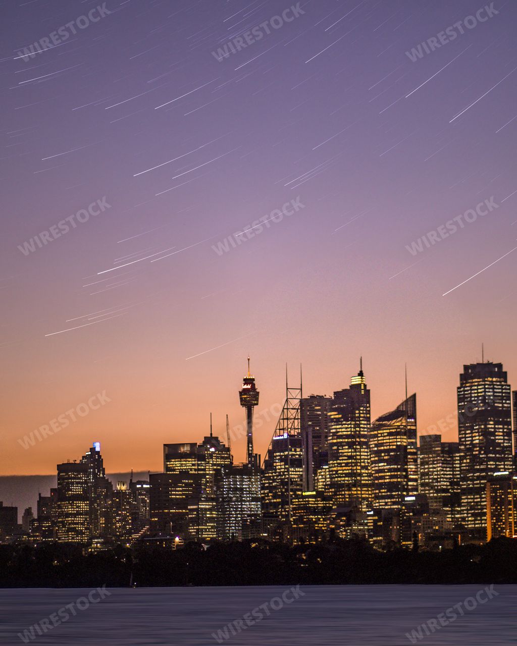 A beautiful long range shot of Sydney, Australia skyline at night with stars falling