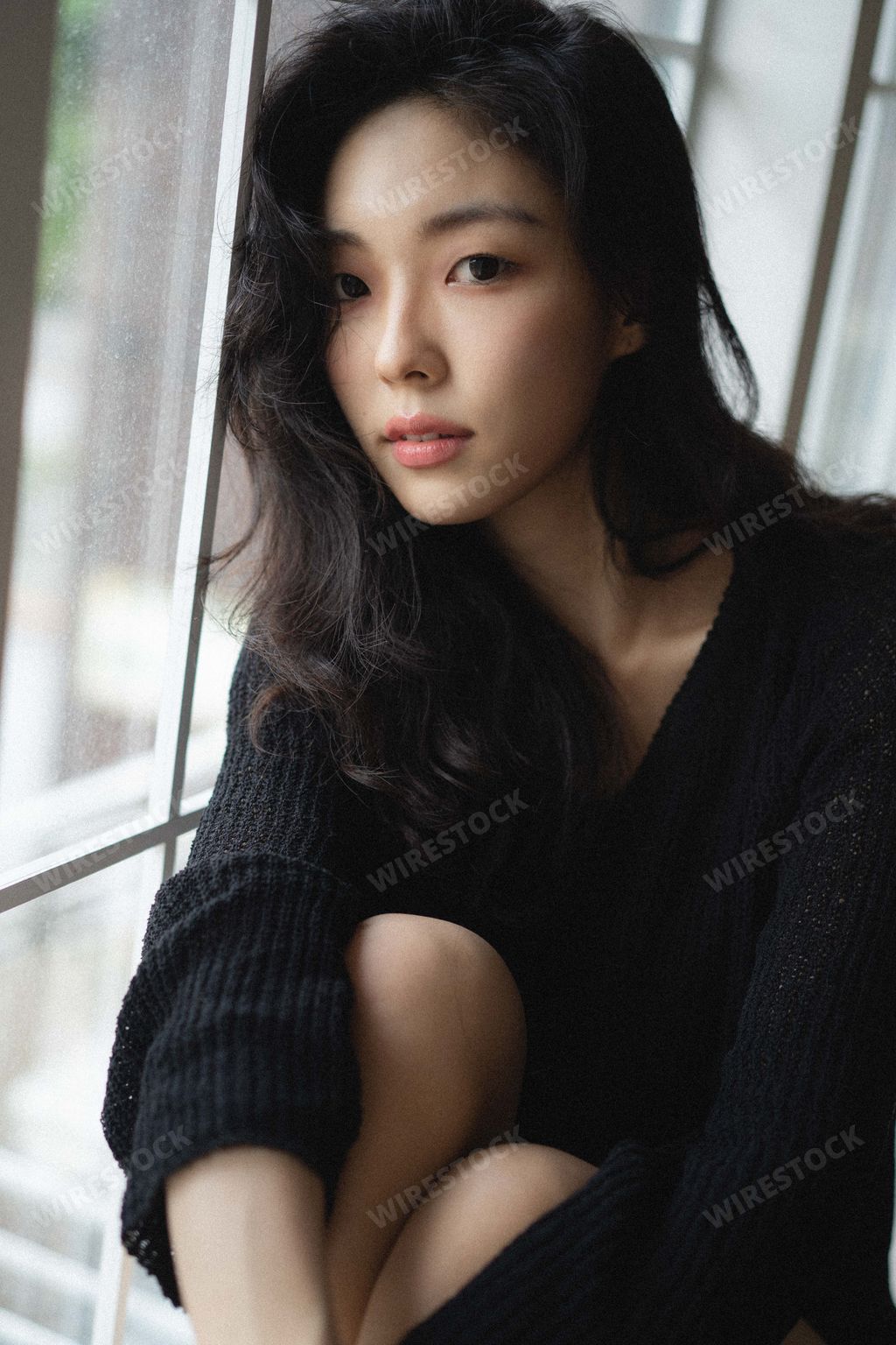 A beautiful South Korean female sitting on the windowsill