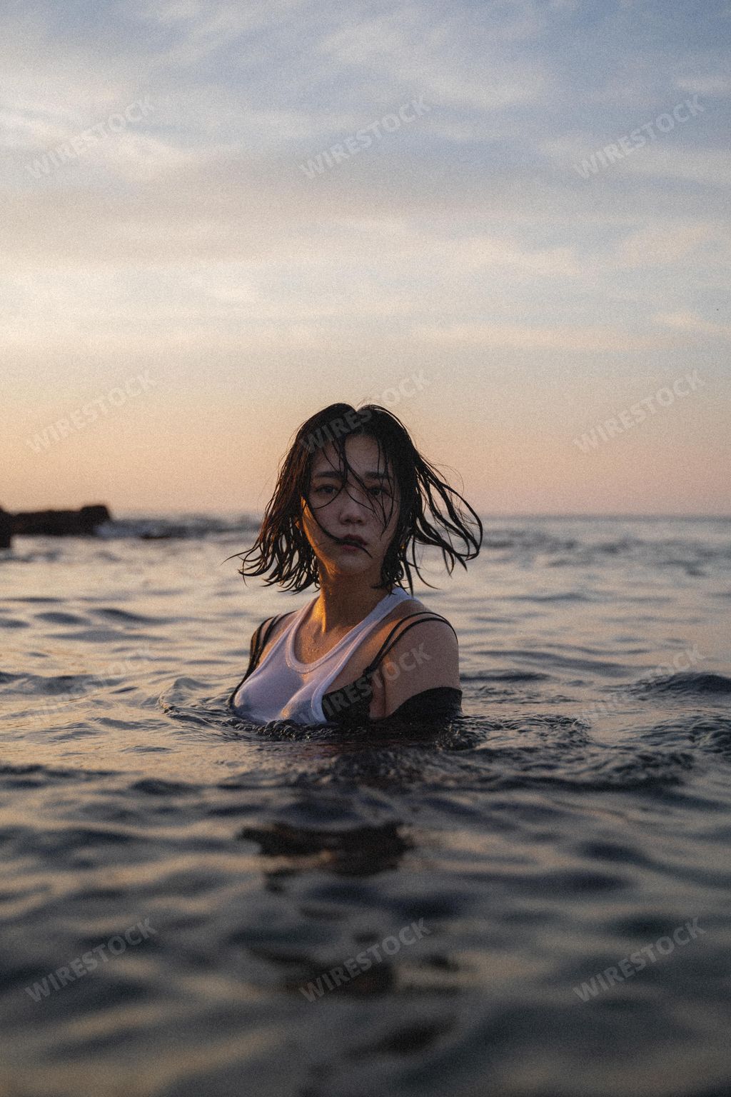 A vertical shot of an attractive South Korean female in the water