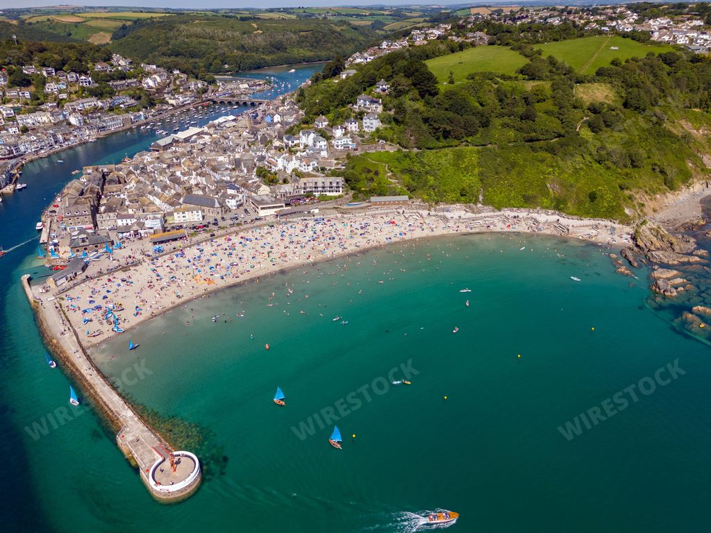 An aerial view of the scenic town of Looe with its harbor and houses on a sunny day, Cornwall, England