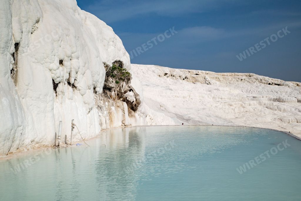 A scenic view of the travertine terraces and thermal pools on a sunny day in Pamukkale town in western Turkey