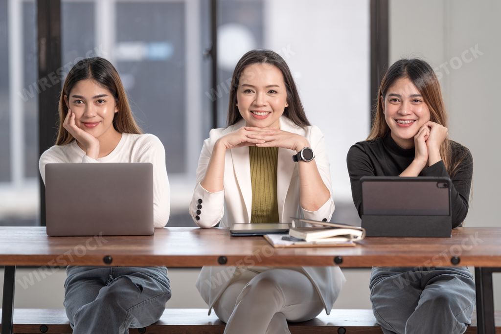 A horizontal shot of three Asian beautiful females posing with a smiles