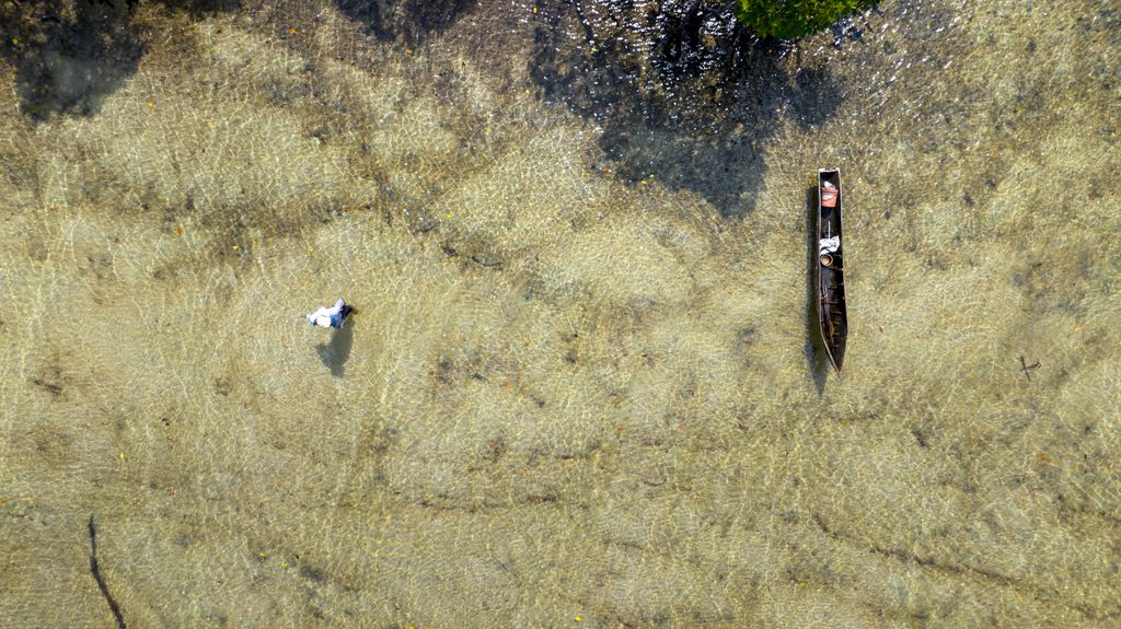 An aerial view of a boat peacefully floating in Mangroove in Palma District in Cabo Delgado, Mozambique