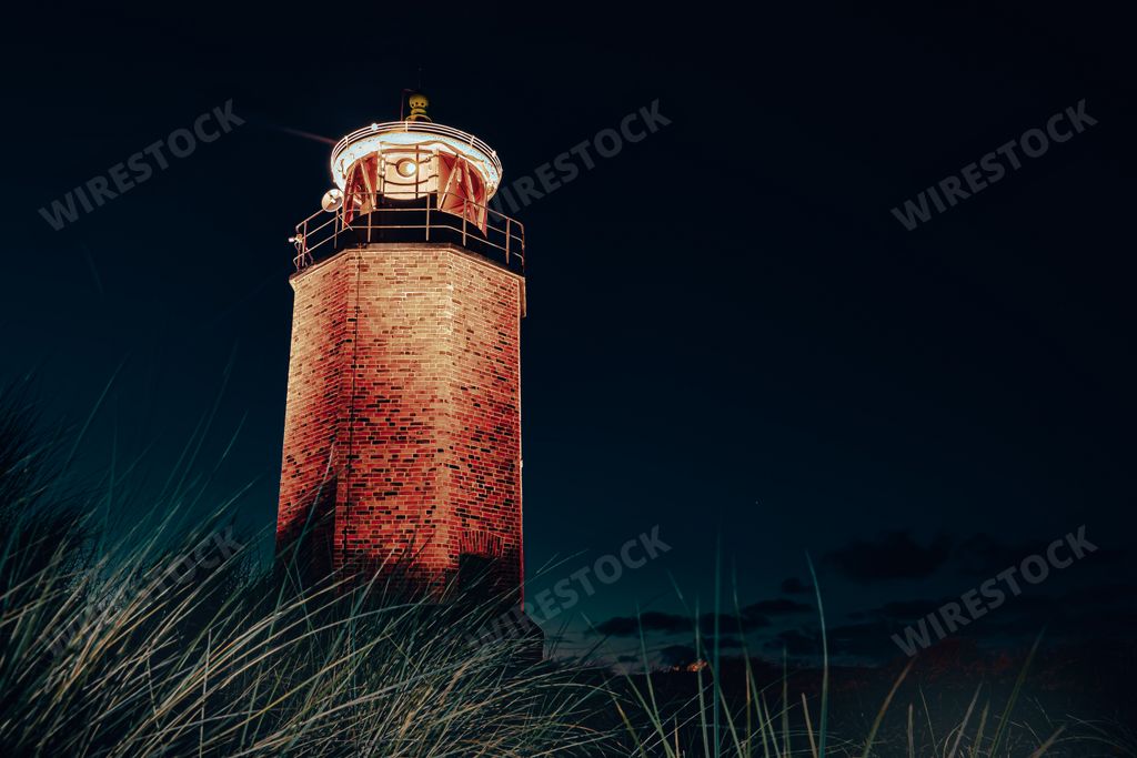 A closeup shot of a lighthouse on the night sky background
