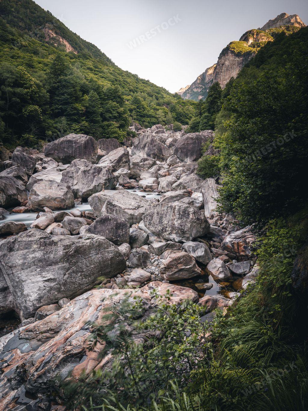 A vertical shot of stones in a mountainous area covered with greenery, Lavertezzo, Switzerland, Canton Ticino