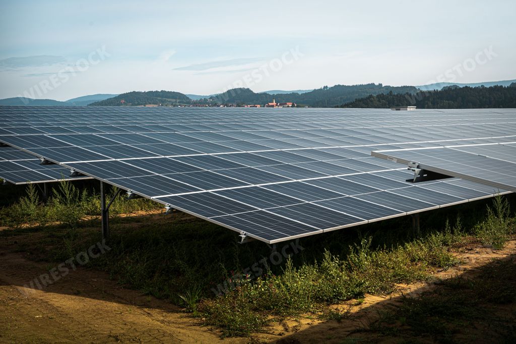 The solar system panels in the large photovoltaic power plant in the green field