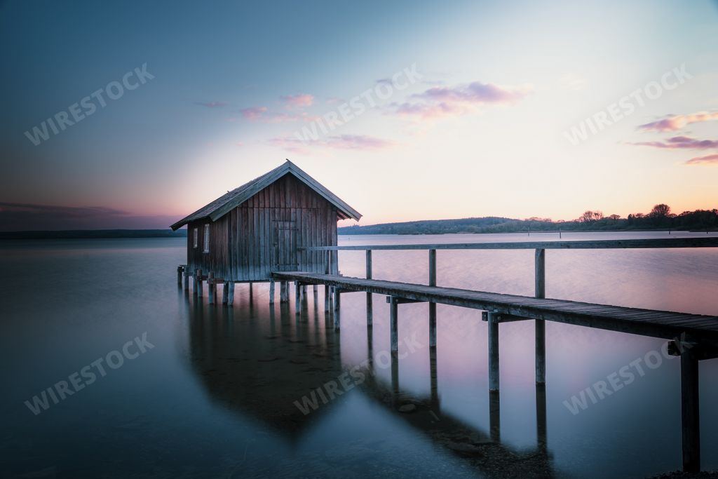 An old boathouse at lake Ammersee in Bavaria, Germany against the sunset